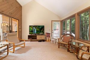 a living room with a tv and a piano at Split Rock Classic Chalet – Game Room & Family Friendly in Pocono Pines
