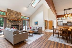a living room with a stone fireplace and a dining room at Split Rock Classic Chalet – Game Room & Family Friendly in Pocono Pines