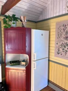 a kitchen with a white refrigerator in a room at Isans stuga in Broby +7 photos