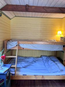 two bunk beds in a room with a desk at Isans stuga in Broby
