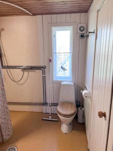 a small bathroom with a toilet and a window at Isans stuga in Broby