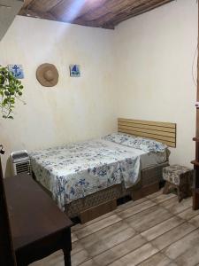 a bedroom with a bed and a hat on the wall at Hospedagem Mandala in Ubatuba