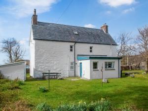 a white house with a picnic table in the yard at Seafield House in Lochinver