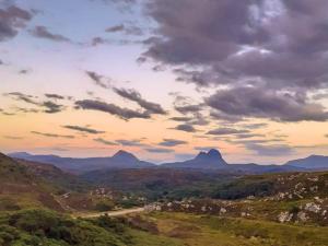 a view of a valley with mountains under a cloudy sky at Seafield House in Lochinver