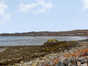 a rocky shore with a body of water at Seafield House in Lochinver