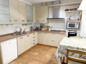 a kitchen with white cabinets and a sink and a table at La Casa de Luna Lunera in Córdoba