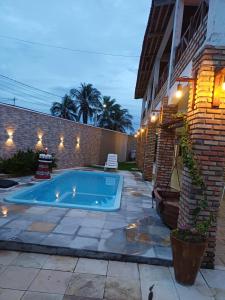 a swimming pool in a yard next to a building at Pousada Farol da Barra in Tutóia