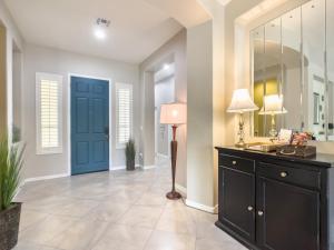 a hallway with a blue door and a table with a lamp at Anthem Allure in Phoenix