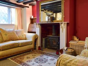 a living room with a fireplace and a mirror at Rebecca's Cottage in Ashby Saint Ledgers