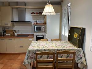 a kitchen with a table with chairs and a microwave at La Casa de Luna Lunera in Córdoba
