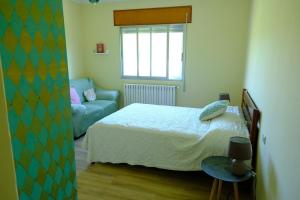 a bedroom with a bed and a chair and a window at Casa Rural Barxa in Monforte de Lemos +31 photos