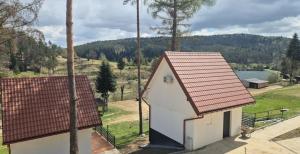 a small white building with a red roof at Resort ELSK Sekowski Krempna in Krempna