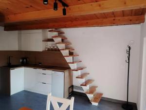 a wooden staircase in a kitchen with a white wall at Resort ELSK Sekowski Krempna in Krempna