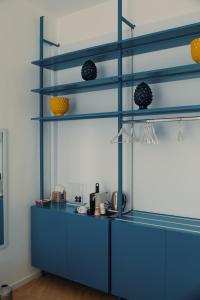 a kitchen with blue cabinets and shelves in a room at Andrew suites in Nettuno +96 photos