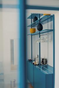 a blue room with a shelf with items on it at Andrew suites in Nettuno