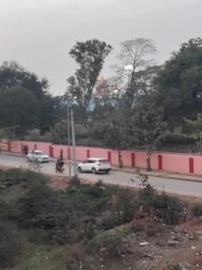a street with cars and a pink wall at Hotel Murlidhar in Chikāra