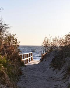 a wooden path leading to the beach with the ocean at Prie jūros in Melnragė +8 photos