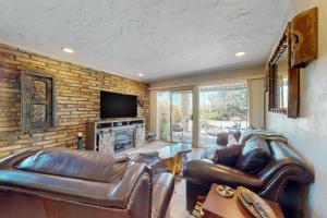 a living room with a leather couch and a fireplace at Tranquil Trail #8 in Carefree