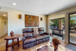a living room with a leather couch and a table at Tranquil Trail #6 in Carefree