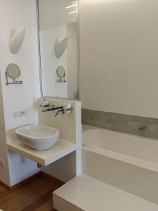 a white bathroom with a sink and a mirror at White Stylish Apartment 4 in Vico Equense