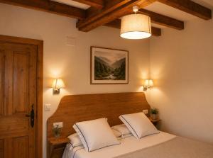 a bedroom with a bed with a wooden head board at Posada El Hoyal in Pesaguero-La Parte +27 photos