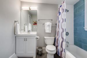 a bathroom with a toilet and a sink and a shower at Historic Downtown Marble Falls- 2 Suite Combo 13 in Marble Falls +22 photos