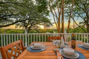 a wooden table with plates of food and a bottle of wine at Historic Downtown Marble Falls- 2 Suite Combo 13 in Marble Falls