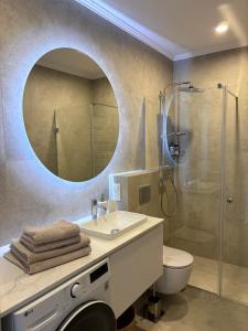 ein Badezimmer mit Waschbecken und Dusche mit Spiegel in der Unterkunft Cool Monkey Studio in Starogard Gdański + 16 Fotos