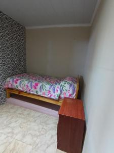 a small bedroom with a bed and a wooden table at Espacio Pueyrredón in Comodoro Rivadavia