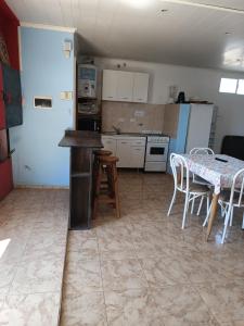 a kitchen with a table and a table and chairs at Espacio Pueyrredón in Comodoro Rivadavia +1 photo