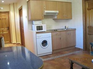 a kitchen with a washing machine and a microwave at La Ventana De Tejera Negra in Cantalojas