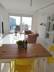 a living room with a wooden table and yellow chairs at White Stylish Apartment 4 in Vico Equense +43 photos