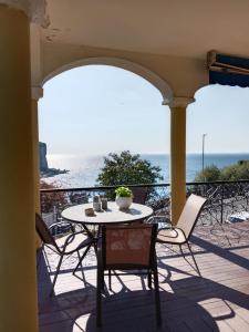 a table and chairs on a balcony with a view of the ocean at White Stylish Apartment 4 in Vico Equense