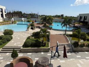 Eine Person geht an zwei Schwimmbecken vorbei. in der Unterkunft Ana condo at Primeworld District in Agus