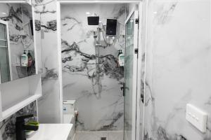 a shower in a bathroom with a marble wall at Nadi Easy Home Near McDonalds in Nadi +37 photos