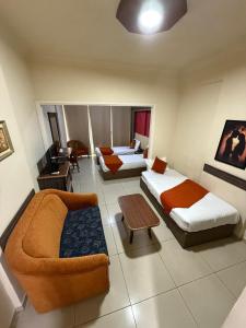a hotel room with two beds and a couch at Elysee Residence in Beirut