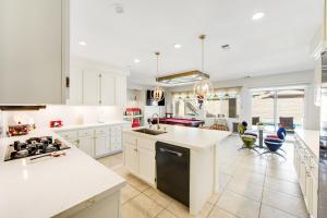 a kitchen with white cabinets and a stove top oven at Casa Whimsy in Indio +33 photos