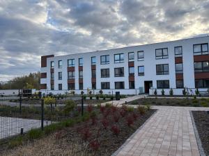 ein großes weißes Gebäude mit einem davorliegenden Innenhof in der Unterkunft Cool Monkey Studio in Starogard Gdański