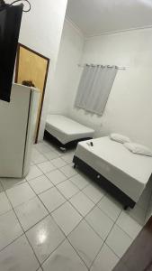 a white room with two beds and a mirror at Pousada Só Alegria in Fortaleza