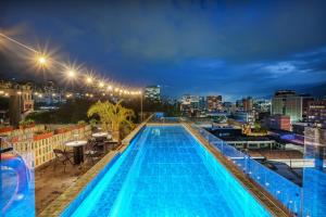 a swimming pool on the roof of a building at night at Hotel Zelva Negra in Medellín