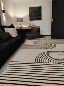 a living room with a black couch and a rug at Little Nuek in Largs
