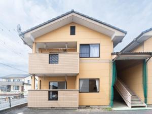 a yellow building with a steep pitched roof at Coucou! in Takasaki