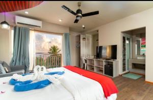 a bedroom with a bed with two swans on it at Ukulhas Villa Hotel & Spa in Ukulhas