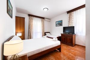 a hotel room with a bed and a tv at Villa MD in Budva +16 photos