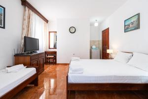 a bedroom with two beds and a tv in it at Villa MD in Budva