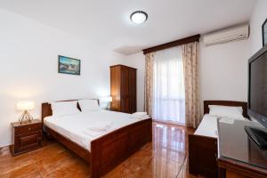 a bedroom with two beds and a flat screen tv at Villa MD in Budva