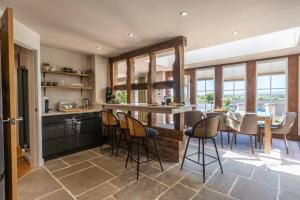 a kitchen with a bar with chairs and a table at Cedar Lodge Severn Stoke in Severn Stoke