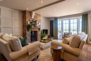 a living room with two couches and a fireplace at Cedar Lodge Severn Stoke in Severn Stoke