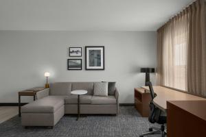 a living room with a couch and a desk at Residence Inn Boise West in Boise +26 photos