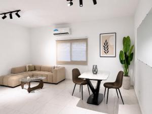 a living room with a couch and a table and chairs at Silver Apartment Abidjan in Abidjan